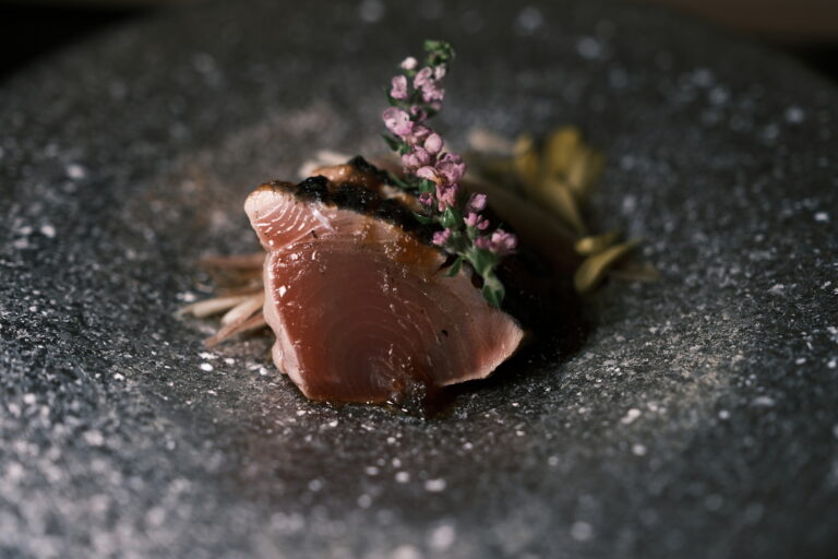 Omakase in SG : A chef blending Japanese tradition presenting a dish with refined detail.