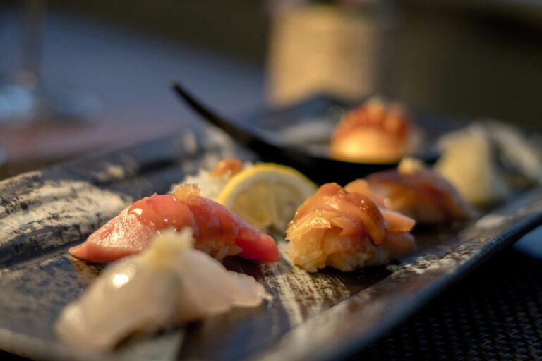 The image showcases an elegant sushi presentation featuring multiple small dishes artfully arranged on traditional lacquerware, highlighting the beauty of Japanese cuisine. This fine dining experience emphasizes seasonal ingredients and culinary mastery, inviting diners to embark on a culinary journey through signature dishes in a Japanese restaurant setting.