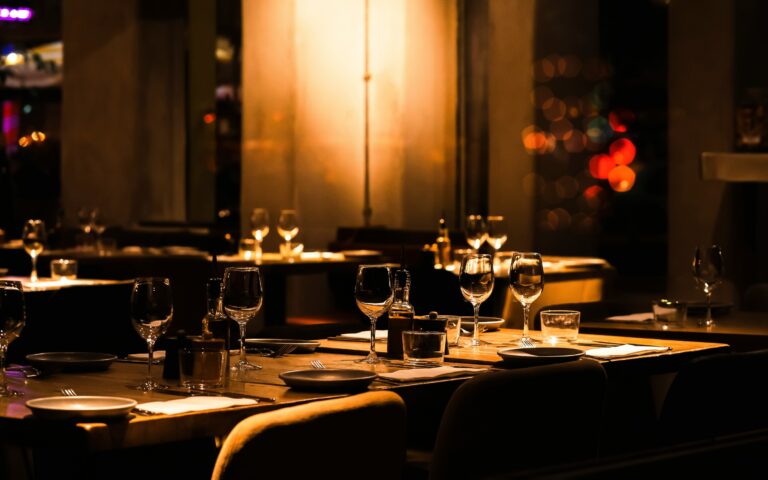 Fine Dining in SG : The image showcases an elegant fine dining restaurant interior, featuring sophisticated lighting that enhances the ambiance and meticulously arranged table settings. This luxurious space, ideal for special occasions, reflects the high standards of fine dining in Singapore, promising an unforgettable dining experience complemented by impeccable service.