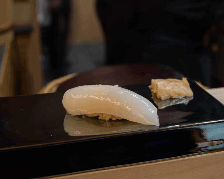 A close-up of traditional Japanese sushi arranged neatly on a wooden board, showcasing refined craftsmanship and delicate textures.