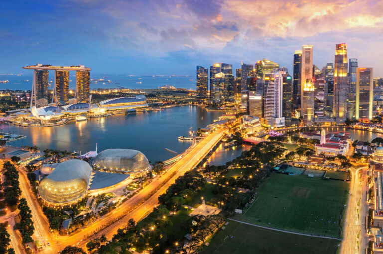 Breathtaking panoramic view of the Singapore city skyline at dusk, featuring the illuminated Marina Bay Sands, the Central Business District, and the domes of the ArtScience Museum.