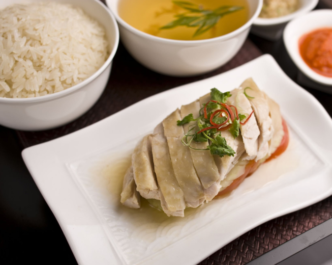Singapore Best Food : Iconic Singaporean dishes like Hainanese Chicken Rice, perfectly plated with fragrant rice and spicy chilli sauce.