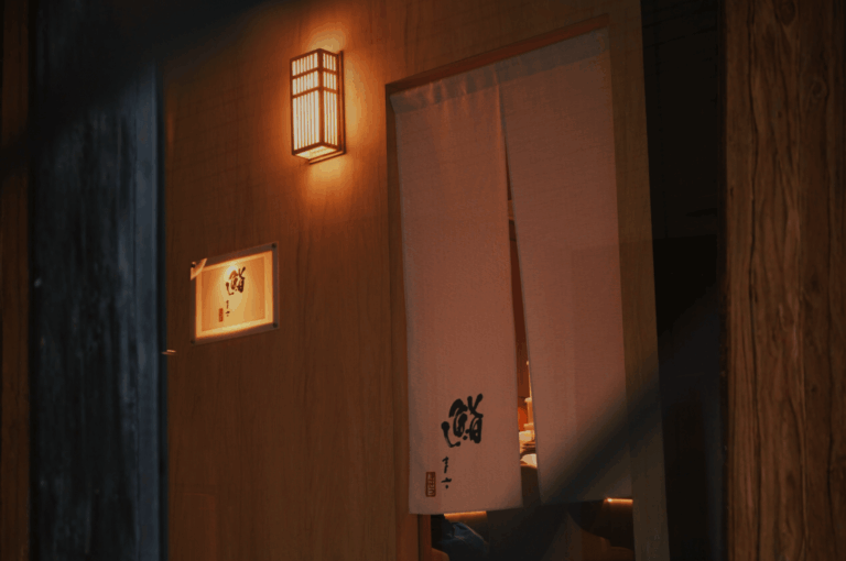 Entrance to Sushi Masa, Singapore’s premier omakase destination, framed by a traditional noren curtain and softly glowing lantern. The warm interior light and elegant Japanese calligraphy evoke authenticity and quiet sophistication, inviting diners into an intimate culinary experience that defines Orchard Road’s sushi excellence.