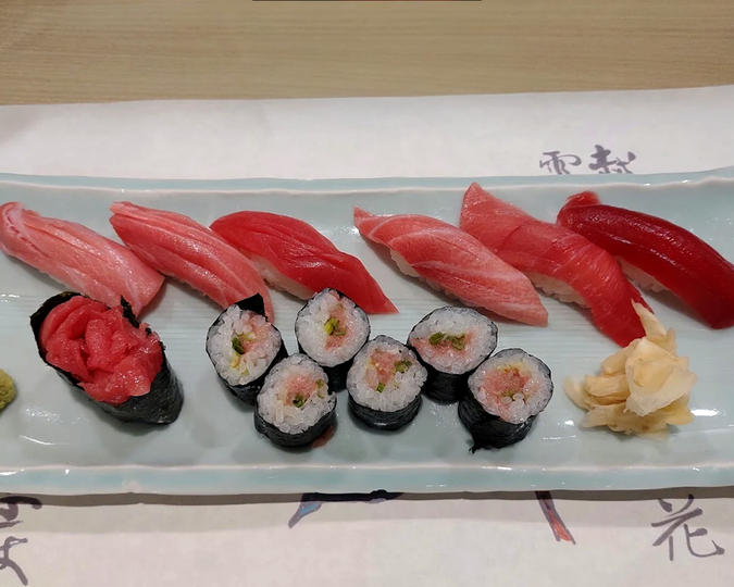 A beautifully plated assortment of fresh sushi from Tomi Sushi, showcasing premium cuts of tuna, salmon, and white fish.