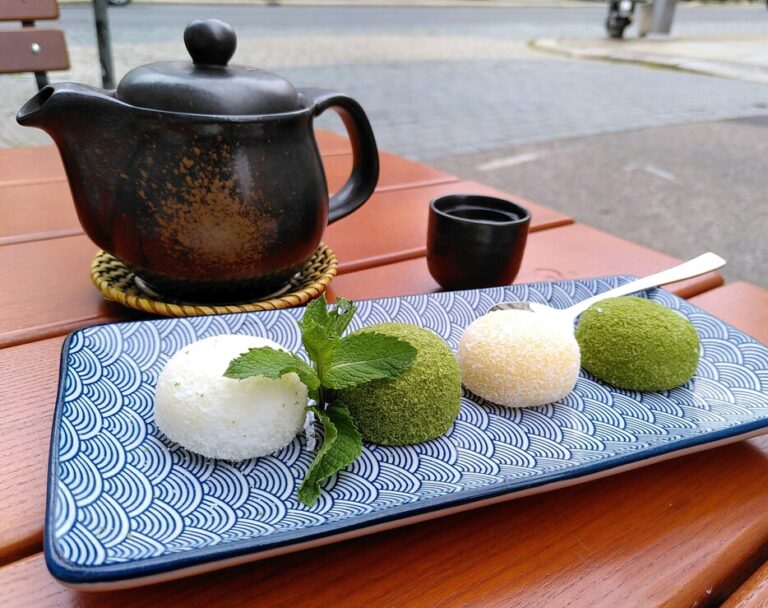 Japanese Food in SG : A delicate plate of mochi served alongside a cup of freshly brewed green tea, capturing the serene essence of traditional Japanese dessert culture
