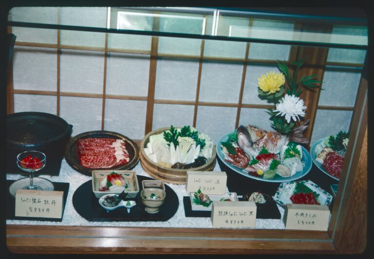 Japanese Food in SG : A vintage photograph depicting the early history of Japanese cuisine, highlighting chefs preparing sushi and tempura in a classic setting.