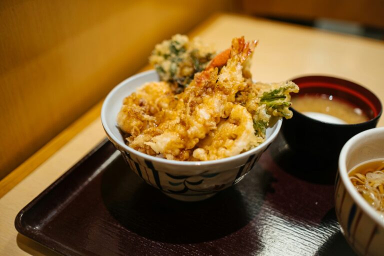 Japanese Food in SG : A perfectly fried tempura assortment of shrimp and vegetables, crisp and golden, placed beside dipping sauce for an authentic Japanese meal experience.