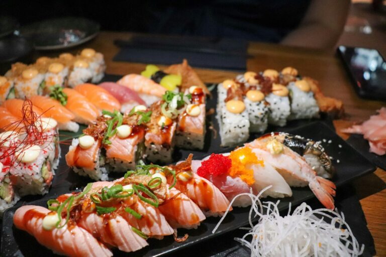 A vibrant assortment of sushi showcasing different types and textures, artfully arranged on a wooden platter.