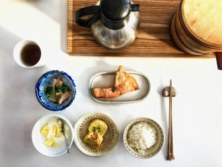 Japanese Food in SG : A wholesome Japanese breakfast featuring grilled fish, steamed rice, tamagoyaki, and pickled vegetables served in elegant tableware.