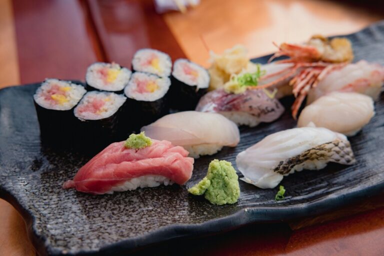 A beautifully arranged wooden board showcases various pieces of nigiri sushi, featuring different types of fish such as mackerel, medium fatty tuna, and shrimp, all resting on vinegared sushi rice. This colorful sushi selection highlights the artistry of Japanese cuisine, perfect for diners at a sushi restaurant.