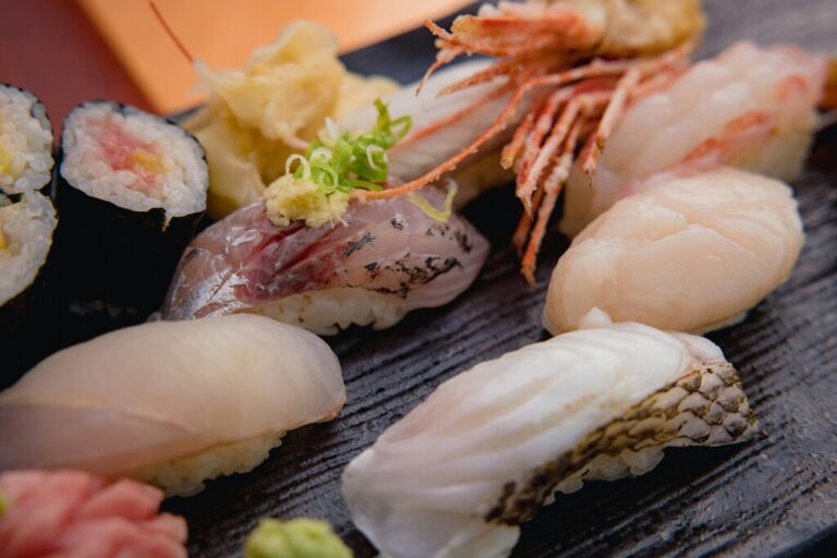 Best food in SG : An assortment of sushi types neatly placed on a ceramic plate, showcasing colourful toppings and traditional presentation