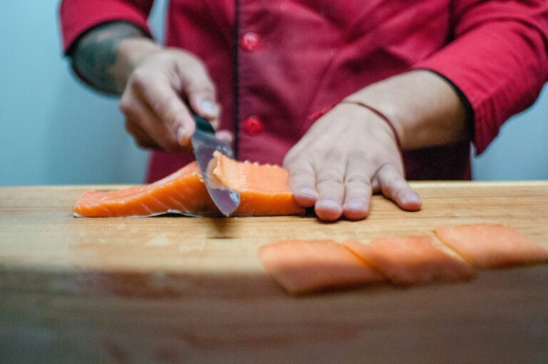 Japanese Food in SG : A skilled chef slicing fresh salmon with precision, demonstrating the artistry and discipline behind Japanese culinary craftsmanship