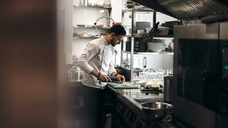 Expensive restaurants in Singapore: Celebrity chef preparing exquisite dishes in a professional kitchen with international flair.