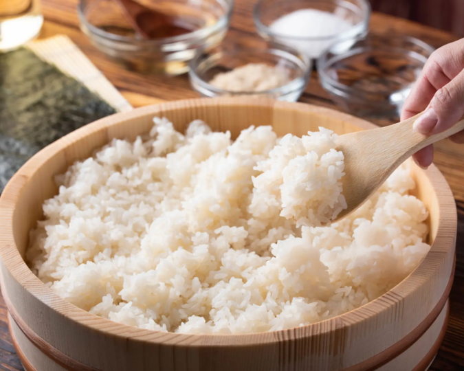 Japan Sushi: Steaming, freshly cooked sushi rice being fanned to perfection, highlighting the craftsmanship behind authentic sushi making.