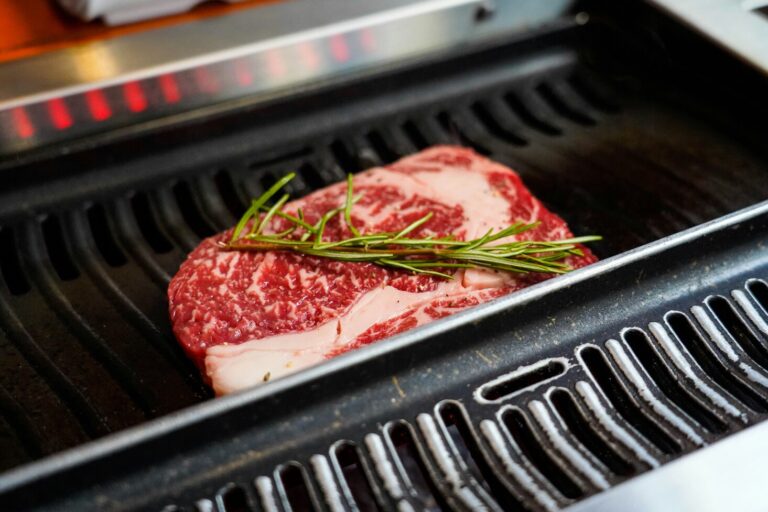 Marbled Wagyu beef sizzles on the grill, its rich fat slowly melting to create a buttery, aromatic sear.