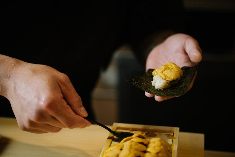 Chef Masa prepares sushi with measured skill and unwavering focus, reflecting the harmony and discipline of Japanese culinary tradition
