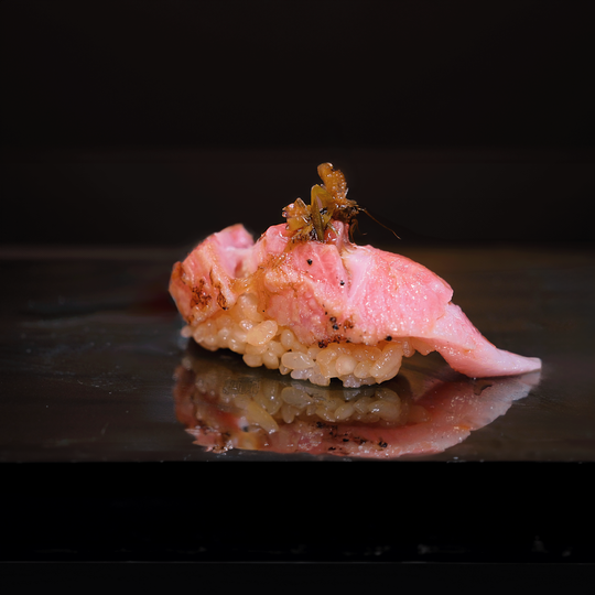 A close-up of a luxury omakase sushi piece, featuring premium fish with a glossy finish atop perfectly seasoned rice.