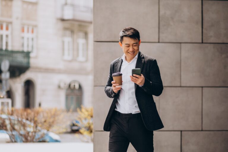 A man holding his phone while securing an omakase reservation, framed in a calm and refined dining atmosphere.