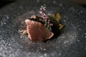 A beautifully plated slice of premium fish at Sushi Masa, showcasing delicate texture and natural sheen, arranged with minimalist elegance.