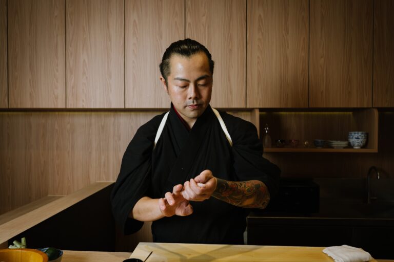 Chef Masa gently shapes sushi by hand, demonstrating refined technique and dedication to traditional Japanese craft.