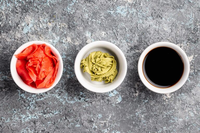 Traditional condiments of soy sauce, wasabi, and pickled ginger artfully arranged beside sushi, offering the perfect balance of flavour and seasoning