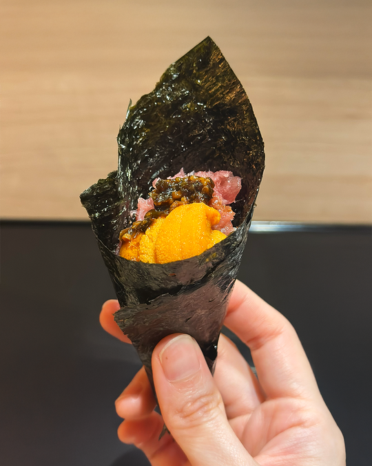 A carefully presented sushi dish held in hand, highlighting delicate craftsmanship, precise plating, and the refined balance of tradition and modern elegance.