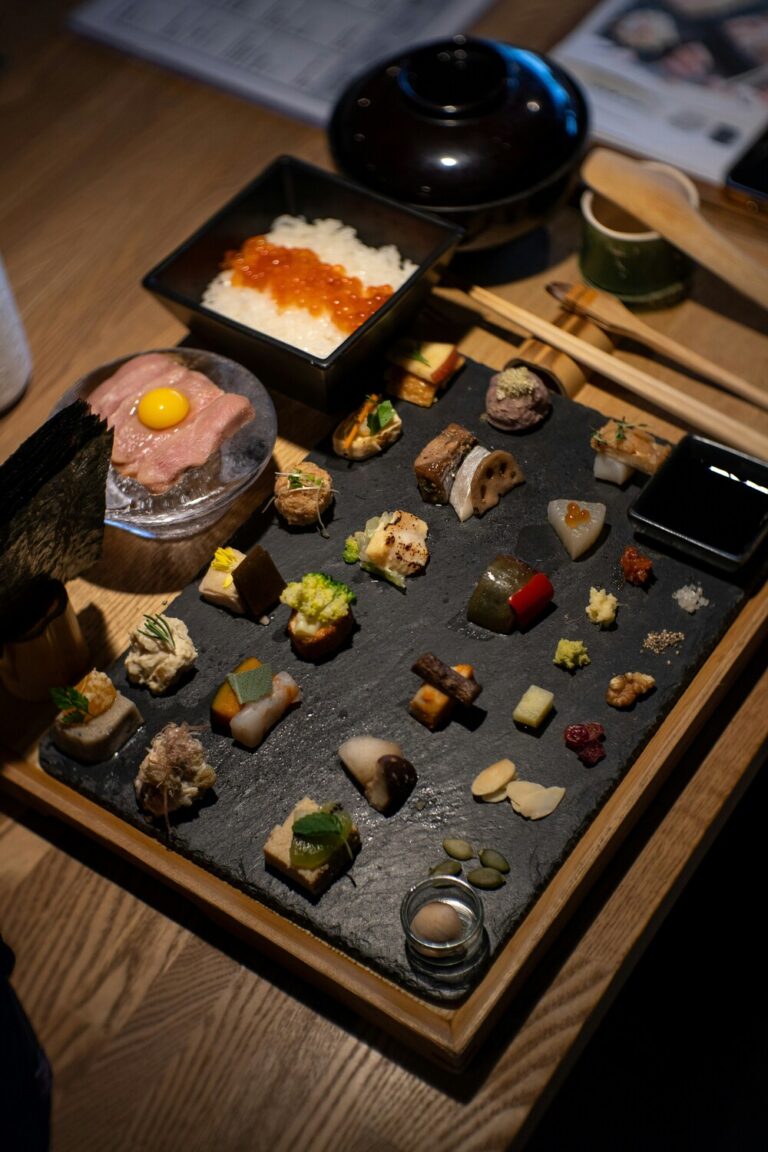 An assortment of sushi varieties displayed on a wooden platter, featuring colourful cuts of fish, expertly shaped rice, and traditional garnishes representing classic Japanese sushi craftsmanship.