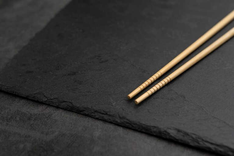 A pair of elegant chopsticks rests on the edge of a plate, complementing the refined presentation of the sushi meal