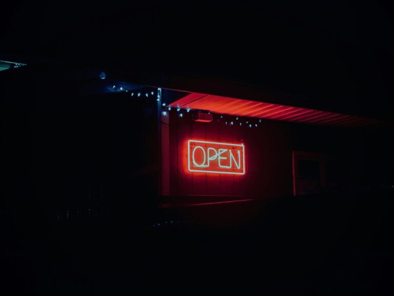 A warmly lit 'Open' sign greets guests outside Sushi Masa, inviting them into a serene and authentic Japanese dining experience