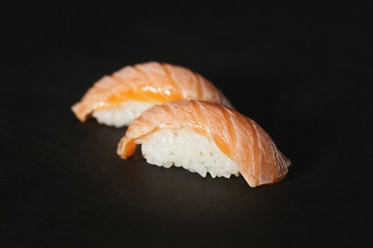 Two beautifully crafted sushi pieces set on a clean plate, highlighting balance, simplicity, and understated elegance
