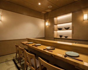 A serene Japanese restaurant featuring an intimate private dining room, designed with warm wood tones and minimalist décor for a refined and exclusive dining experience.