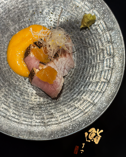 Chef Masa focused in quiet concentration, embodying the singular artistry of a chef whose skill is shaped by tradition, patience, and intuition.