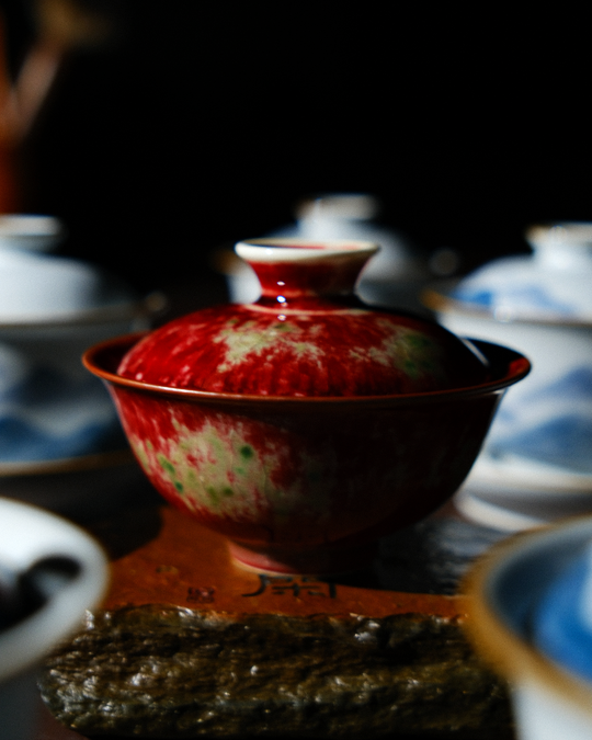 A beautifully glazed red tea bowl resting on a clean, elegant table, showcasing rich colour tones and artisanal details that reflect warmth, balance, and the ritual of mindful tea drinking.