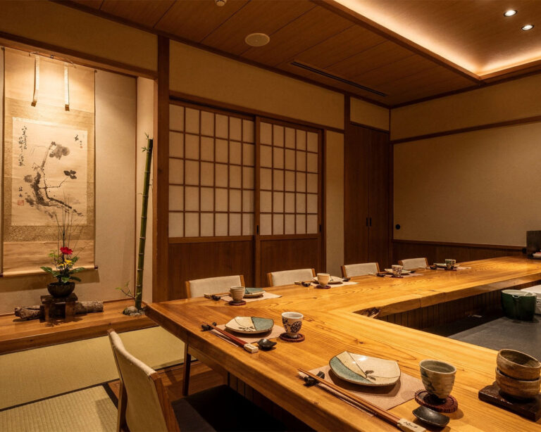 A quiet Japanese restaurant interior featuring a private dining room with warm lighting and wooden details, creating an intimate and exclusive dining atmosphere.