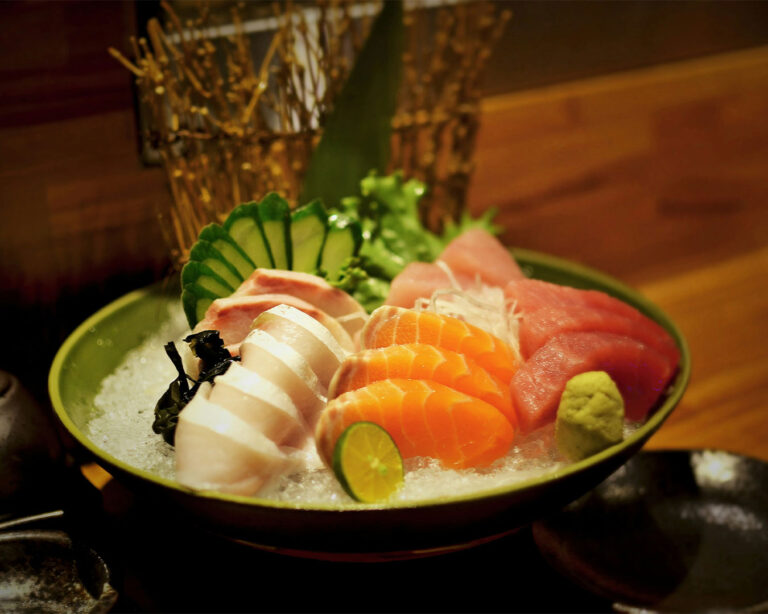 Thinly sliced tuna sashimi arranged neatly on a ceramic plate, showcasing its deep red colour and smooth texture, served fresh to highlight the natural sweetness of the fish.
