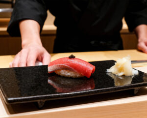 Fresh Edomae sushi neatly arranged on a polished wooden counter, showcasing precise knife work and traditional Japanese presentation in an intimate omakase setting.