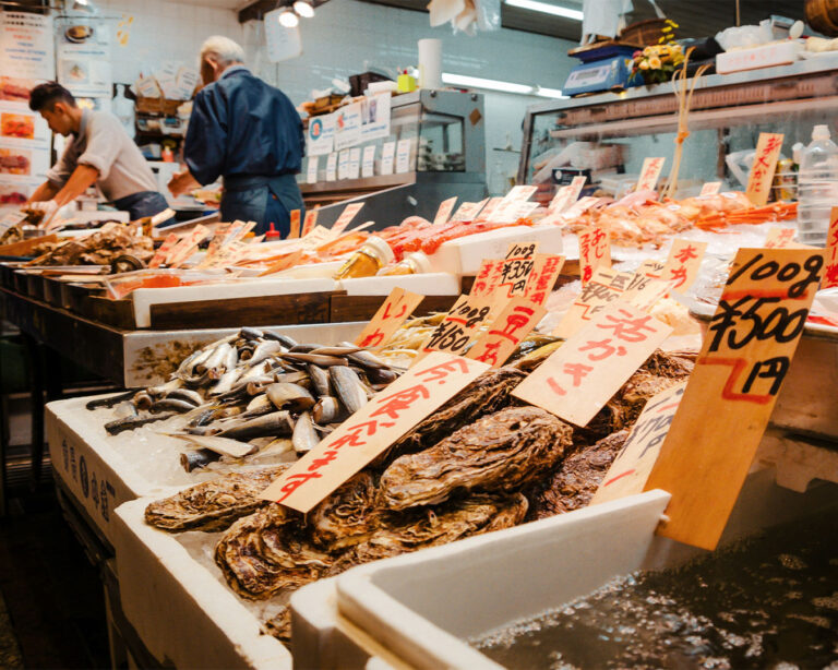 Rows of whole fish and shellfish at the old Tsukiji Market, capturing the heritage of Tokyo’s historic seafood trade and the spirit of traditional fishmongers.