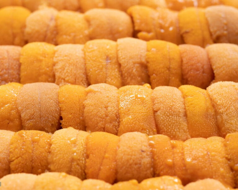 Golden Murasaki uni arranged neatly, with its rich colour and smooth texture standing out, emphasising its luxurious appearance and delicacy.