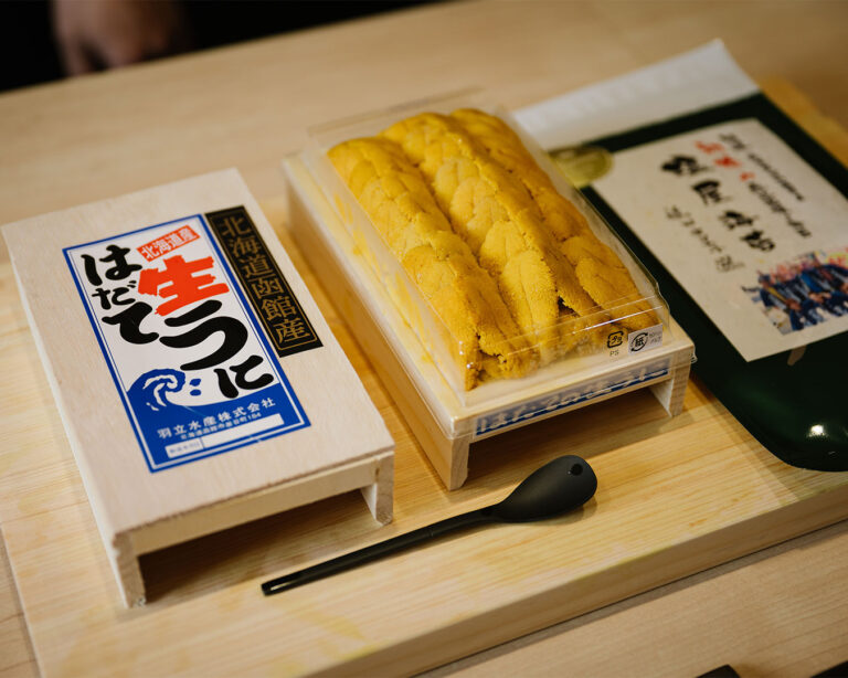 Fresh sea urchin placed on a sushi counter, prepared for serving in a traditional Japanese dining setting.