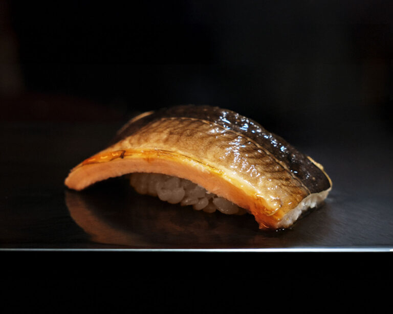 A plate of omakase sushi served in sequence, showcasing seasonal fish with clean presentation and subtle textures that highlight the chef’s curated selection.