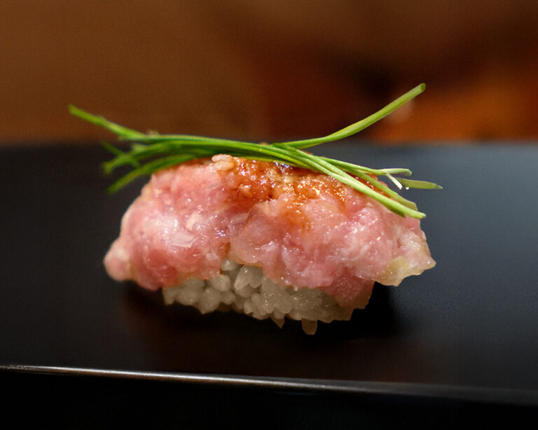 An artfully plated piece of Sushi Masa nigiri, highlighting precise knife work, balanced seasoning, and the natural beauty of premium ingredients.