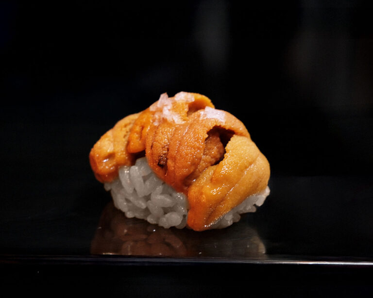 Murasaki uni sushi placed on a plate, featuring creamy uni layered over seasoned sushi rice, presented in a refined and appetising style.