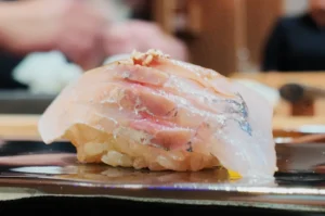 Close-up of omakase nigiri with chilled Japanese sake at Sushi Masa by Ki-setsu in Singapore.