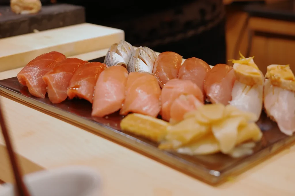 A variety of sushi pieces arranged on a plate, including slices of fish and garnishes.