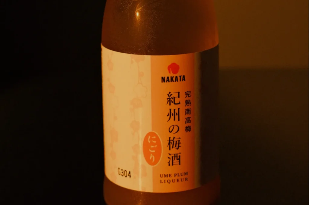 A bottle of Nakata Ume Plum Liqueur with a label featuring Japanese text and a light pink design.