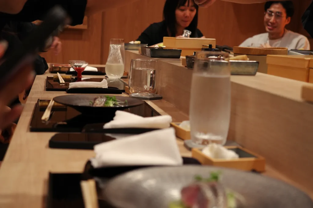 A dining table set with various dishes and drinks, where people are enjoying a meal together.