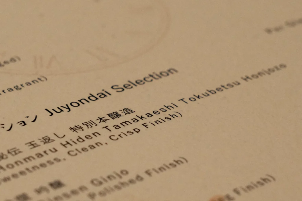 Close-up of a printed whisky menu featuring “Juyondai Selection,” Japanese text, and tasting notes including “clean” and “crisp finish.”