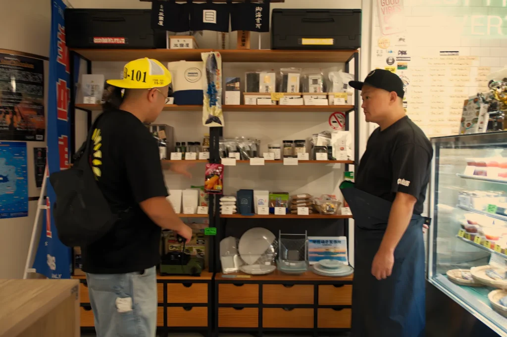 Chef Masa and Araya-san at Araya Shouten discussing products on a display shelf.